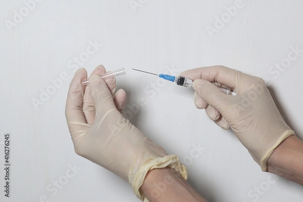 Fototapeta Doctor filling syringe with medication, closeup. Vaccination and immunization