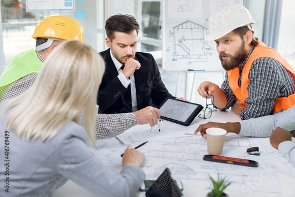 Fototapeta Multiracial office workers having meeting about construction