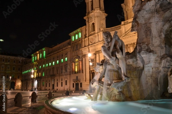 Fototapeta fountain at night in navona Square Rome empty with colored lights