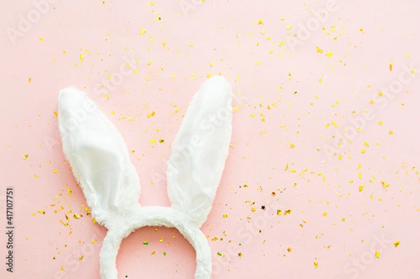 Fototapeta Rabbit ears and egg on a pink background with sparkles.