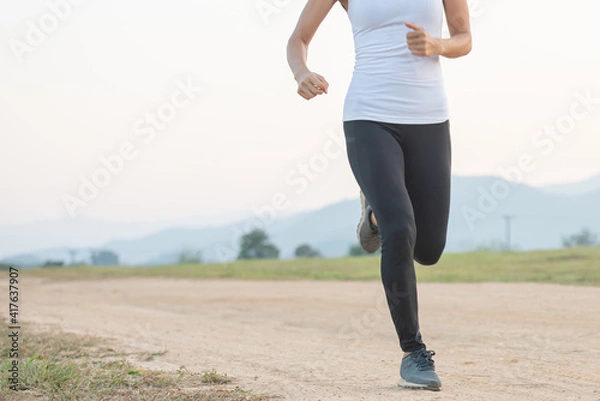 Fototapeta Young lady enjoying in a healthy lifestyle while jogging along a country road, exercise and Fitness and workout on outdoors.