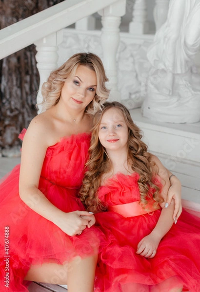 Fototapeta woman with daughter in  dresses.Mom and her child outdoors. Happy family.Beautiful mother and daughter in elegant airy pink dresses with a train in the photo studio.The concept of family love