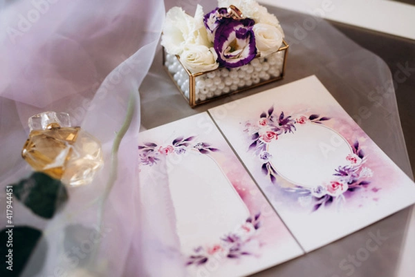 Fototapeta wedding invitation in a gray envelope on a table with green sprigs