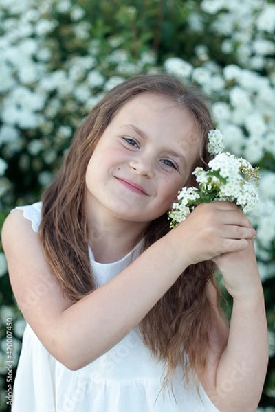 Fototapeta Beautiful preteen girl with long blond hair enjoy spring apple blooming. Little preschool girl in garden tree flowers.