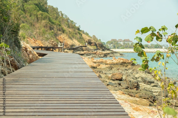 Fototapeta brown wooden bridges along the hillsides rocks on the beach are rocks and  rocky mountains and sea close to island, eco-tourism concept