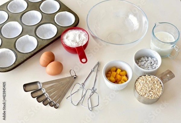 Fototapeta Baking ingredients and kitchen utensils for making healthy gourmet muffins and baked goods. Photo concept, food background, copy space, flay lay, close-up