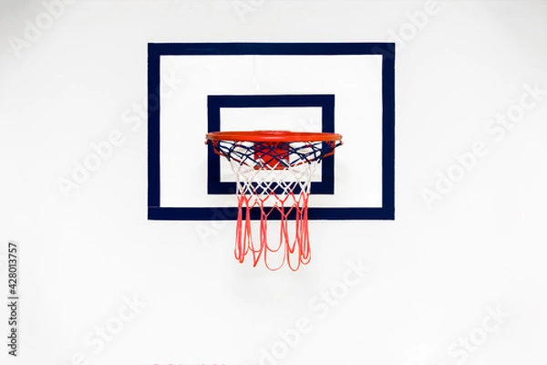 Fototapeta Backboard with red metal basketball hoop hangs on white concrete wall