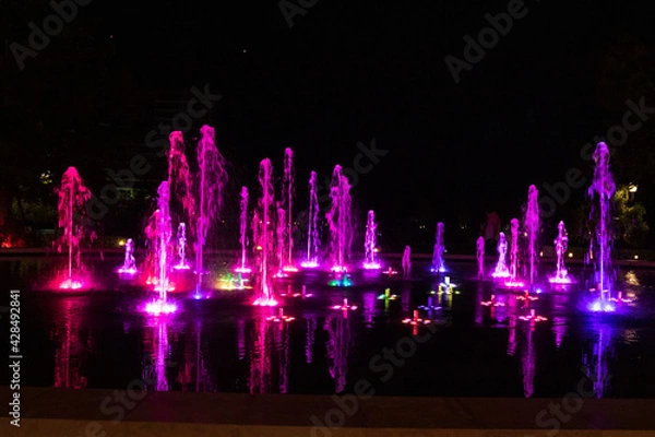 Fototapeta Bright colourful fountain against a dark sky