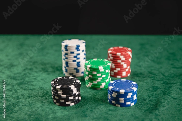 Fototapeta Chips and cards for poker in hand on green table