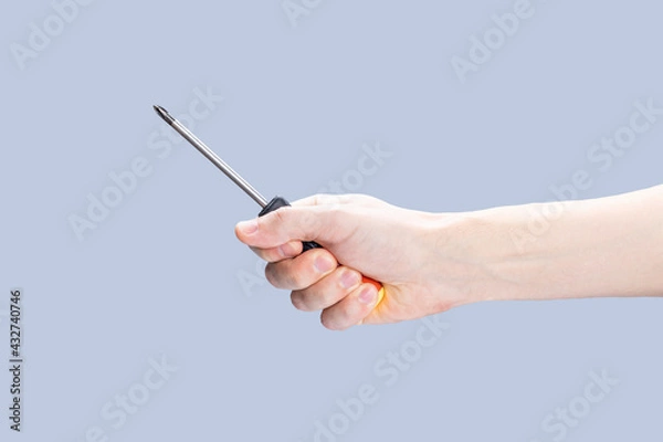 Fototapeta handyman person holding screwdriver isolated over grey background. repair service concept