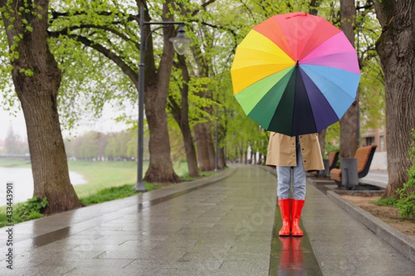 Fototapeta Young woman with umbrella walking in park on spring day