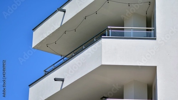 Fototapeta Condominium and apartment building with  symmetrical modern architecture. Detail in modern residential flat apartment building exterior. Fragment of new luxury house and home complex.