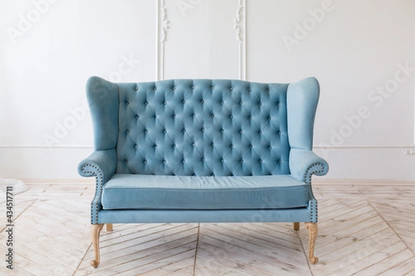 Fototapeta Soft blue sofa in light interior with fabric upholstery