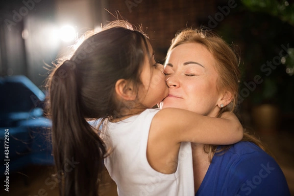 Fototapeta Girl embracing her mother, while she is meditating