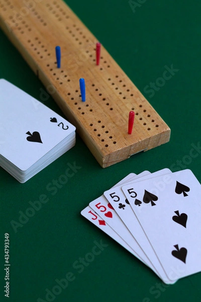 Fototapeta cribbage wooden games.playing card and cribbage board on the green.playing cards with deck on the table. combination of cards on a casino desk background with copy space.top view