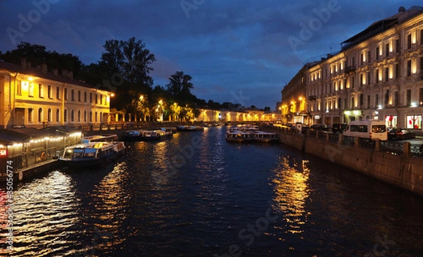 Fototapeta View of pleasure boats on the Moika embankment in St. Petersburg from Zeleny Most on Nevsky Prospekt at night