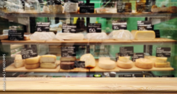 Obraz Empty table or counter for your product or text. Table top, mock up. Defocused image of a counter, a department store with farm cheeses, camembert, brie, goat cheese.