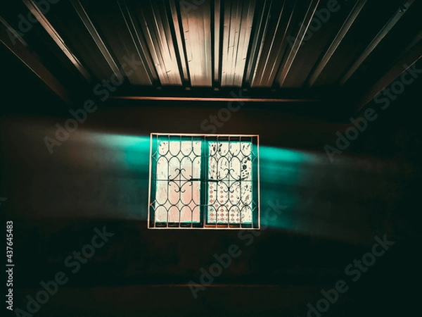 Fototapeta Abstract horror background for halloween. Gloomy scary terrible window with ghostly light and shadows in a dark black room in the attic, corridor or basement in an abandoned house in the forest