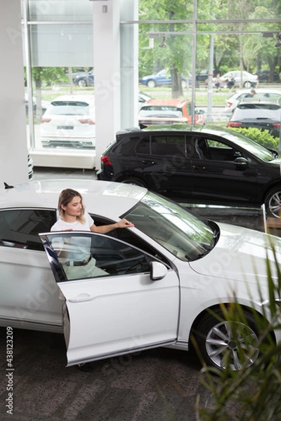 Fototapeta Woman getting inside new automobile at car dealership