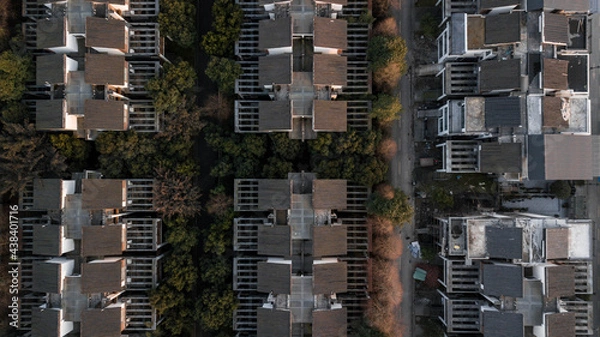 Fototapeta Top down aerial drone view on parallel streets of residential district and duplex cottages in row in Chengdu, China. Some still under construction, autumn time. Houses in suburban area of city