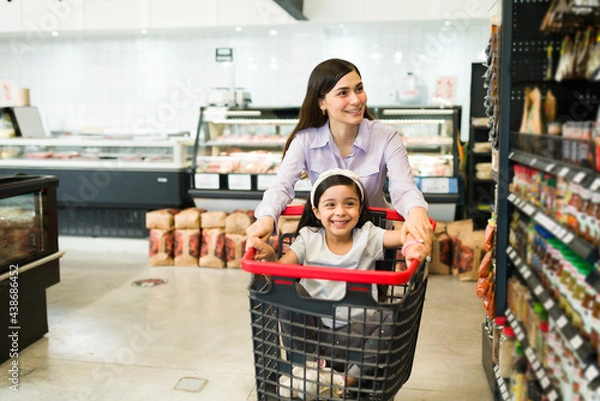 Fototapeta Fun young woman shopping with her kid