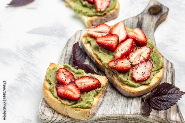 Fototapeta Toast with strawberry guacamole. and chia seeds. Keto diet toast. Delicious breakfast or snack, Clean eating, dieting, vegan food concept. top view