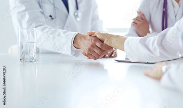 Fototapeta Doctor shaking hands with a male patient in the office