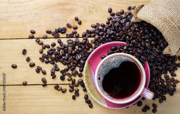 Fototapeta Hot coffee espresso or americano and coffee bean on older wood table at morning time. Coffee break time.