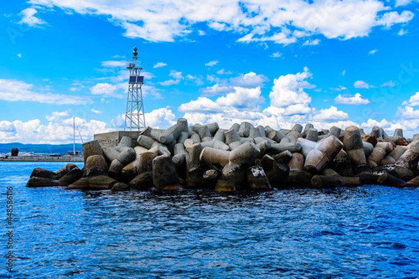 Fototapeta Lighthouse of the port Nessebar in Bulgaria. Coastal defence barrier made of tetrapods on foreground