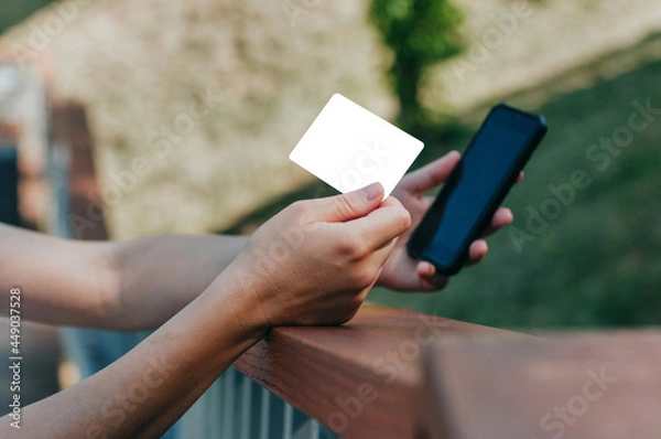 Fototapeta Young woman with headphones making payment using credit card