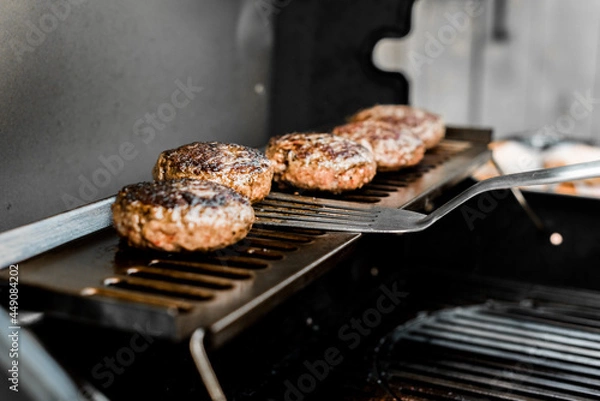 Fototapeta Rindfleisch Burger für Hamburger auf dem Grill mit Käse und Zwiebeln überbacken