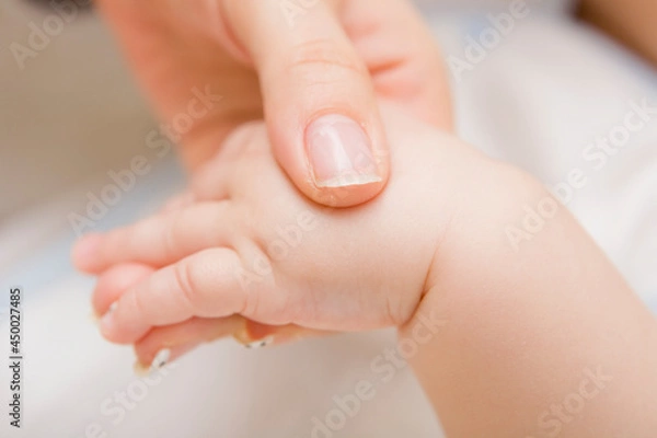 Fototapeta A close up of mother hand holding a baby hand