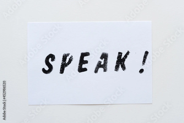 Fototapeta the expression "speak!" stencilled in black on white cards and arranged on a light background