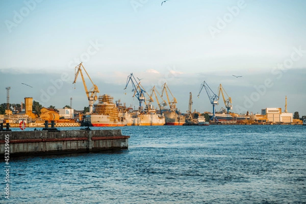 Fototapeta The embankment in the port on Vasilyevsky Island with merchant ships. Saint Petersburg, Russia - 24 June 2021