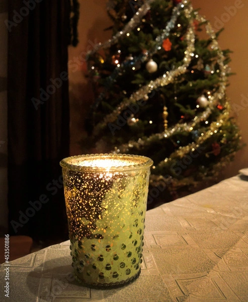 Fototapeta New Year and Christmas decorations. Burning a decorative candle with a Christmas tree    