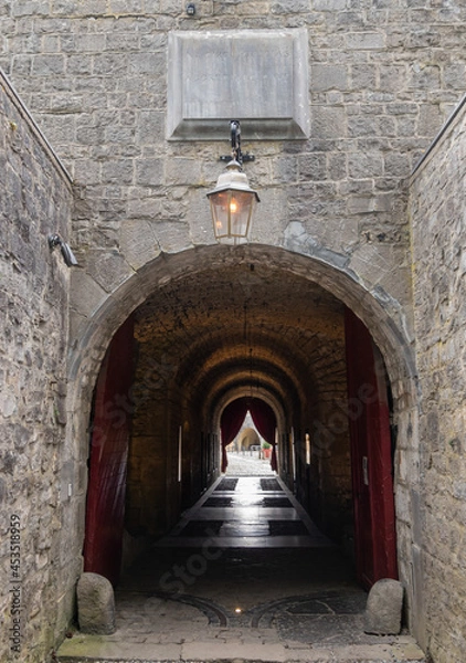 Fototapeta Dinant, Wallonia, Belgium - August 8, 2021: Citadel Fort. Corridor under building housing offices, jails, and officers quarters leads to inner courtyard.