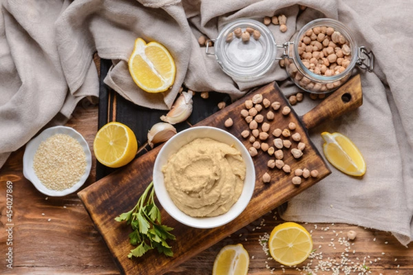 Fototapeta Composition with tasty hummus and ingredients on wooden background