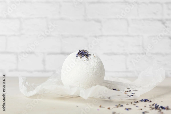 Fototapeta Lavender bath bomb on table near light brick wall