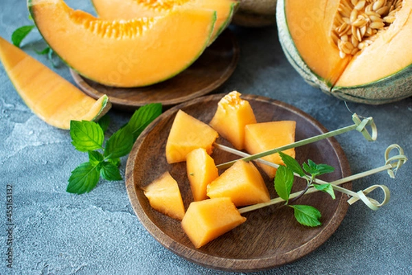 Fototapeta pieces of melon on a plate on a concrete table