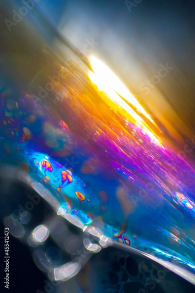 Fototapeta View into a microscopic world of soap bubbles, uncovered light, artistic multicolored surreal detail.