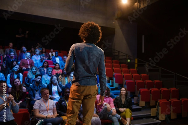 Fototapeta Male speaker on stage talking to audience