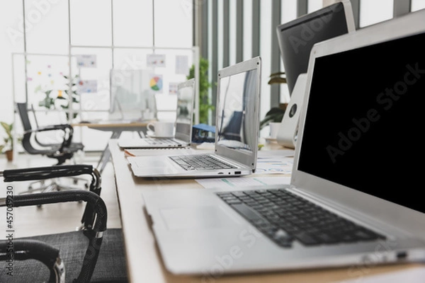 Obraz Selective focus on laptops sitting on conference table in meeting room office with multiple glass windows in background