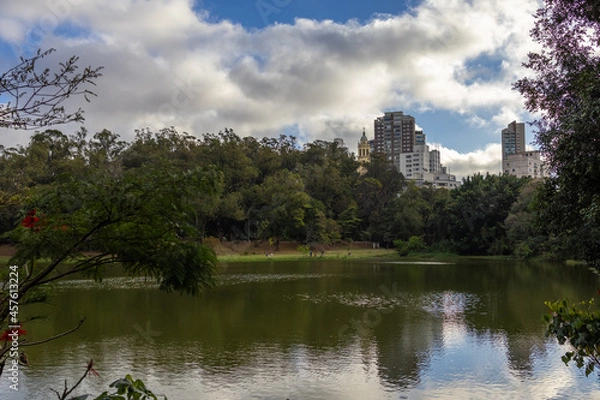 Fototapeta Paisagem do parque da Aclimação em São Paulo incluindo um lago e os prédios da cidade ao fundo