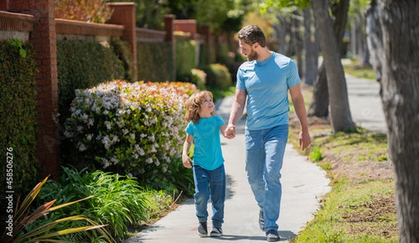 Fototapeta happy father with son walking together in park, happy family