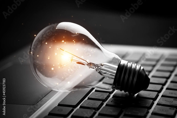 Fototapeta light bulb on laptop keyboard. concept of Innovative ideas, knowledge, inspiration, creativity