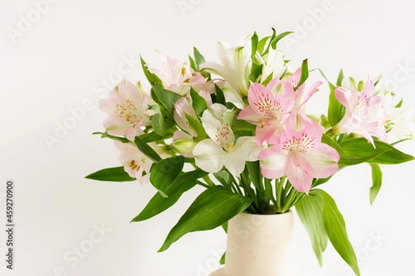 Fototapeta Flowers bouquet in a vase close up on white background.  White and pink Alstroemeria flowers. Poster