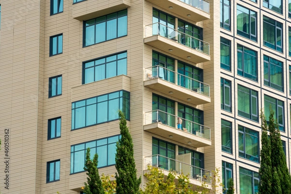 Fototapeta Beige house with balconies and blue windows