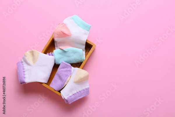 Fototapeta Wooden box with different socks on pink background