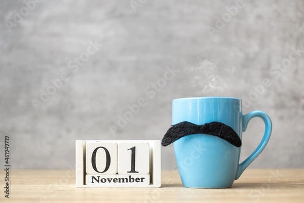 Fototapeta November 1 calendar, Blue coffee cup or tea mug and Black mustache decor on table. Men day, Happy father day and Hello November concept