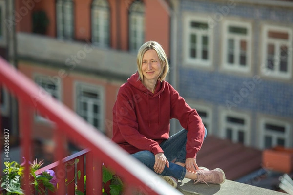 Fototapeta A woman outdoors in autumn against the blurred background of the town.